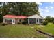 Exterior view of brick home with a red roof, sunroom, screen porch, and mature landscaping at 3338 Passmore Rd, Rock Hill, SC 29730