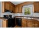 Galley kitchen with wood cabinets, black appliances, and granite counters at 3338 Passmore Rd, Rock Hill, SC 29730