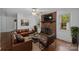 Bright living room showcasing a fireplace, wood floors, a leather sofa, and a ceiling fan at 3338 Passmore Rd, Rock Hill, SC 29730