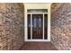 Elegant dark brown front door with glass accents and brick entryway at 426 Saint Michaels Way, Fort Mill, SC 29708