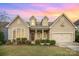 Inviting two-story home with a landscaped front yard, dormer windows, and an attached two-car garage at 7037 Hyde Park Dr, Indian Trail, NC 28079