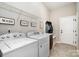 Bright laundry room featuring a washing machine, dryer, utility sink, and folding signs at 7037 Hyde Park Dr, Indian Trail, NC 28079