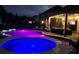 Night view of the backyard with an illuminated pool, hot tub, and lounge seating perfect for evening relaxation at 7037 Hyde Park Dr, Indian Trail, NC 28079