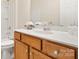 Bathroom with wooden vanity, a white sink, and a toilet with a shower in the background at 2105 Kennedy Dr, Indian Land, SC 29707