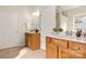 Bathroom with a double sink vanity with wood cabinets, tile floors, and a view of the outside at 2105 Kennedy Dr, Indian Land, SC 29707