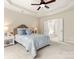 Bedroom with tray ceiling and en-suite bathroom with a soaking tub viewed through open doors at 2105 Kennedy Dr, Indian Land, SC 29707