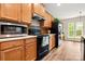 Kitchen with wood cabinets, black appliances, and a decorative tile backsplash at 2105 Kennedy Dr, Indian Land, SC 29707