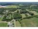 Overhead view of a property featuring a lush green lawn, pond, and a home nestled among the trees at 3814 Watson Church Rd, Monroe, NC 28110