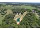 Picturesque aerial view showcasing a pond and lush greenery, complemented by a home surrounded by tall trees at 3814 Watson Church Rd, Monroe, NC 28110