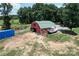 Aerial view of a red barn, boat, and other outbuildings surrounded by green fields at 3814 Watson Church Rd, Monroe, NC 28110