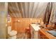 Rustic bathroom with wood-paneled walls, features a toilet, sink and vanity area, with tiled floors at 3814 Watson Church Rd, Monroe, NC 28110