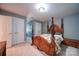 Comfortable bedroom featuring a four poster bed, a beige carpet, and closet space at 3814 Watson Church Rd, Monroe, NC 28110