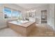 Luxurious bathroom with soaking tub, double vanity, and large windows at 3012 Wheatfield Dr, Waxhaw, NC 28173