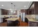 Island kitchen with dark wood cabinets and granite countertops at 3012 Wheatfield Dr, Waxhaw, NC 28173