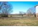 Large backyard with a lush lawn, mature trees providing shade, and a glimpse of the home's exterior at 2725 Carla Dr, Shelby, NC 28150