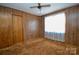 Bedroom features wood paneling, ceiling fan, carpet, window and closet at 2725 Carla Dr, Shelby, NC 28150