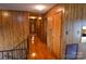 Hallway with hardwood floors, wood paneled walls, and multiple doorways at 2725 Carla Dr, Shelby, NC 28150