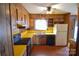 Retro kitchen featuring wood cabinetry, yellow countertops, and standard appliances for cooking at 2725 Carla Dr, Shelby, NC 28150