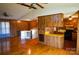 Open-concept layout with hardwood floors, wood paneling, ceiling fans and adjacent kitchen area at 2725 Carla Dr, Shelby, NC 28150