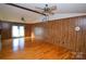 Spacious living room featuring wood paneling, hardwood floors, ceiling fans, and a bright window with sheer curtains at 2725 Carla Dr, Shelby, NC 28150