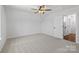 Spacious bedroom with neutral carpet, ceiling fan, and door to an en suite at 4684 Hopsack Dr # Cal0105, Indian Trail, NC 28079
