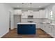 Modern kitchen with white cabinets, island, stainless appliances, subway tile backsplash, and hardwood floors at 4684 Hopsack Dr # Cal0105, Indian Trail, NC 28079