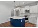 Modern kitchen boasts stainless appliances, white cabinets, blue island, and sleek quartz countertops at 4684 Hopsack Dr # Cal0105, Indian Trail, NC 28079