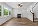 Bright living room with hardwood floors, staircase, fireplace, and large windows overlooking the yard at 4684 Hopsack Dr # Cal0105, Indian Trail, NC 28079