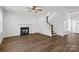 Spacious living room featuring hardwood floors, a fireplace, a staircase, and a glass front door at 4684 Hopsack Dr # Cal0105, Indian Trail, NC 28079