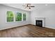 Bright living room featuring hardwood floors, a fireplace, large windows, and a modern ceiling fan at 4684 Hopsack Dr # Cal0105, Indian Trail, NC 28079
