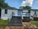 Back of home with sliding glass door, stairs to backyard and small deck and railing at 6261 Burnhurst Ln, Denver, NC 28037