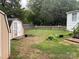 Backyard featuring a storage shed, a white picket fence, and scattered vegetation, offering a private outdoor space at 6261 Burnhurst Ln, Denver, NC 28037