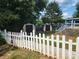 Backyard featuring two storage sheds, a white picket fence, a wooden deck with stairs, and mature trees at 6261 Burnhurst Ln, Denver, NC 28037