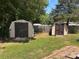 Backyard featuring two storage sheds, lush greenery, and a glimpse of a wooden fence, providing a secluded feel at 6261 Burnhurst Ln, Denver, NC 28037
