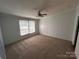 Neutral bedroom featuring plush carpets, a window for natural light, and a ceiling fan at 6261 Burnhurst Ln, Denver, NC 28037