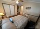 Bright bedroom showcasing a white frame bed, overhead fan, and a built in cabinet at 193 Marina Dr, New London, NC 28127