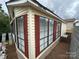 Corner of the home with red shutters and multiple windows, offering plenty of natural light at 193 Marina Dr, New London, NC 28127