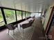 Relaxing sunroom with lake views and stylish wicker furniture on top of patterned rug at 193 Marina Dr, New London, NC 28127