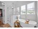 Bright bathroom featuring a soaking tub, a separate glass-enclosed shower, and natural light from two windows at 7245 Static Way, Sherrills Ford, NC 28673