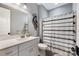 Clean bathroom with white vanity, black and white shower curtain, and tiled floor at 5811 Kristi Ln, Midland, NC 28107