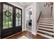 Bright entry with black French doors, hardwood floors, laundry room, and staircase at 5811 Kristi Ln, Midland, NC 28107