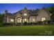 Elegant brick home with a manicured lawn at dusk at 8516 Mcilwaine Rd, Huntersville, NC 28078