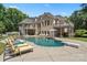 Stunning pool and backyard oasis with lounge chairs and diving board at 8516 Mcilwaine Rd, Huntersville, NC 28078