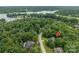 Aerial view of a lakefront property with a wooded lot and nearby houses at 2593 Cozy Cove Dr, York, SC 29745