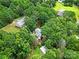An aerial view displays a house nestled among mature trees with a driveway and surrounding foliage at 9143 Sadlers Ridge Rd, Fort Mill, SC 29707