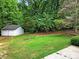 Backyard featuring green grass, wooded perimeter and a detached 2-car garage at 9143 Sadlers Ridge Rd, Fort Mill, SC 29707