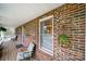 Covered brick front porch with chair, green lantern, and white ceiling at 9143 Sadlers Ridge Rd, Fort Mill, SC 29707