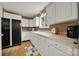 A functional kitchen featuring white cabinetry, black refrigerator, a sink under a window, and modern appliances at 9143 Sadlers Ridge Rd, Fort Mill, SC 29707