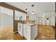 An open-concept living space with hardwood floors, and a view into the kitchen from the adjacent Gathering room at 9143 Sadlers Ridge Rd, Fort Mill, SC 29707