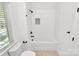 Clean bathroom with white tiled shower-tub combo and pebble tile detail at 3230 Rogers St, Charlotte, NC 28208